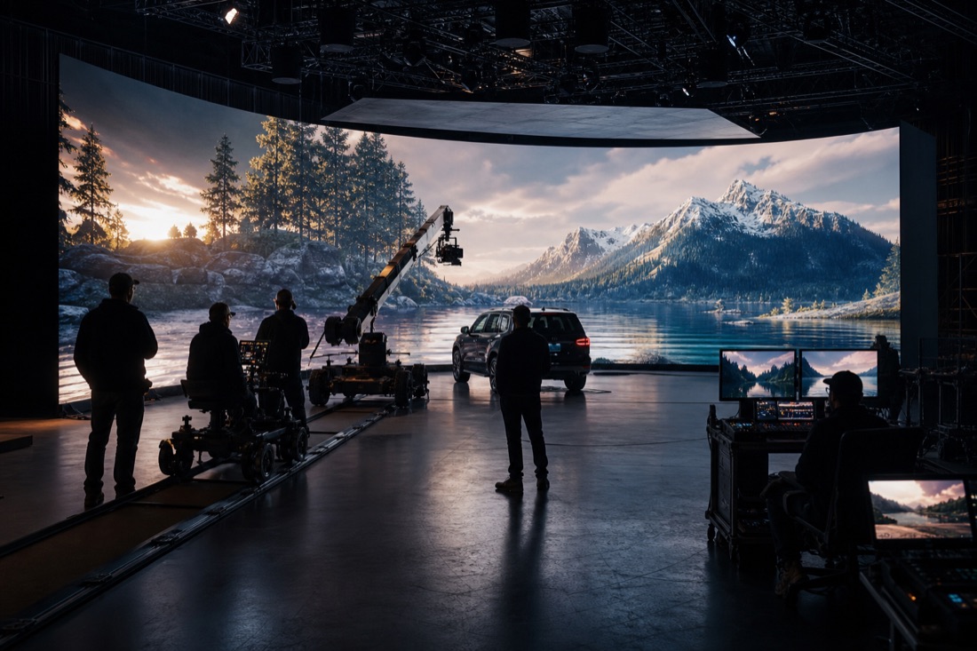 Virtual production LED stage with crew and scenic wall.